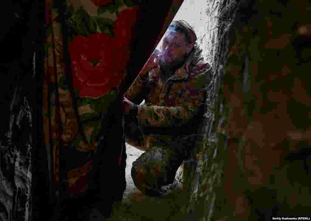 A soldier enjoys a cigarette near the unit&#39;s dugout. &nbsp;
