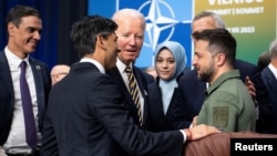 Prim-ministrul britanic Rishi Sunak (stânga) discută cu președintele ucrainean Volodimir Zelenski (dreapta) și cu președintele american Joe Biden în timpul unei reuniuni a Consiliului NATO-Ucraina la Vilnius, la 12 iulie.