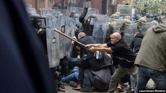 Protestues serbë duke u përleshur me pjesëtarë të KFOR-it, në hyrje të objektit të Komunës së Zveçanit, Kosovë, më 29 maj 2023.