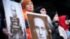 Demonstranti drže slike sa Vladimirom Putinom i Aleksejem Navaljnim na skupu u blizini ruskog konzulata u New Yorku nakon vijesti o smrti Navaljnog 16. februar 2024.