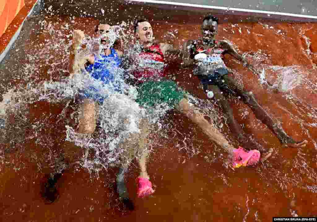 Fituesi i medaljes së artë në kërcim së larti për meshkuj, Gianmarco Tamberi, medalistja e artë në 3000 metra vrapim, Soufiane El Bakkali nga Maroku dhe medalisti i bronztë në 3000 metra vrapim për meshkuj, Abraham Kibiwot nga Kenia, festojnë në Kampionatin Botëror të Vrapimit deri në 3000 metra më 22 gusht 2023.