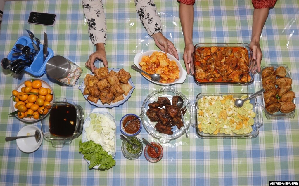 Anëtarët e familjes së Yoni Budiharjos shtruan ushqimin në një tryezë për iftar para se të mbaronin agjërimin e një dite së bashku në shtëpinë e tyre gjatë Ramazanit në Depok, Indonezi, 23 mars 2023.