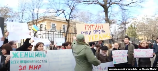 Початок нападу на мітинг жінок біля штабу берегової оборони в Сімферополі: плакат про Путіна розірвуть першим; 5 березня 2014 року