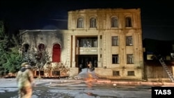 Пожарные у поврежденной огнем в результате нападения боевиков синагоги в Дербенте