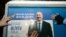 AZERBAIJAN - Electoral officials stick up a poster of Azerbaijani President Ilham Aliyev in Baku on January 15, 2024, on the first day of the official campaigning for the February 7 presidential election.