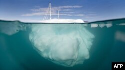 Изследователска ветроходната лодка плава между айсберги, изпуснати от ледници около Милн Ленд във фиорда Скорсби Саунд, Източна Гренландия на 15 август 2023 г. Снимката е част от селекцията на снимките на 2023 на Агенция Франс Прес.