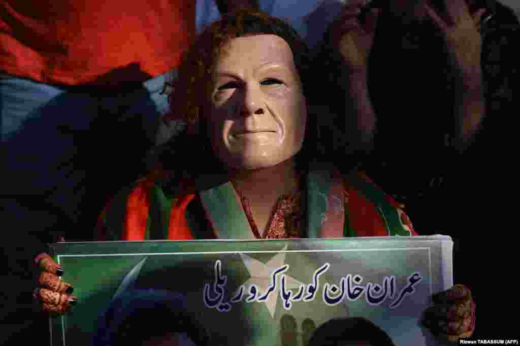Karachi, Pakistan, 21 aprilie. Un suporter al partidului Pakistan Tehrik-e Insaf (PTI) poartă o mască ce-l înfățișează pe Imran Khan, fostul premier, acum întemnițat. La Karachi a fost o manifestație în care s-a cerut eliberarea acestuia.