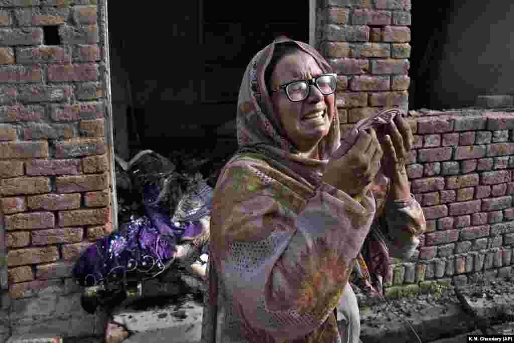 A Christian woman weeps on August 17 after her home was vandalized by an angry Muslim mob the day before.