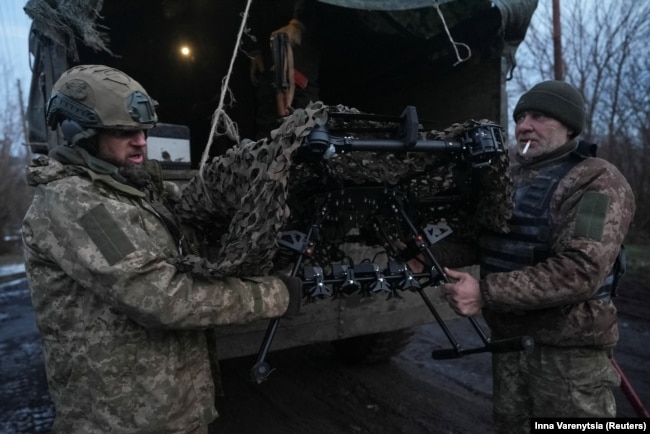 Ushtarët ukrainas të Brigadës 92 të Akilit zbrasin një dron luftarak Vampire pranë qytetit të vijës së parë të frontit në Bahmut më 1 shkurt.<br />
<br />
Gati dy vjet pas pushtimit në shkallë të plotë të Ukrainës nga Rusia, fusha e betejës përgjatë frontit prej gati 1200 kilometrash është ngrirë kryesisht, me të dyja palët që përdorin artileri të kushtueshme precize në distanca të gjata, raketa lundruese të lëshuara nga ajri dhe dronë relativisht të lirë.<br />
