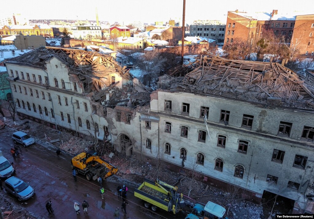 Rrezet e diellit që sapo ka lindur shihen mbi një ndërtesë banimi që u dëmtua rëndë në Harkiv.  