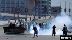 Supporters of former Prime Minister Imran Khan throw stones at police during a protest against his arrest in Peshawar, Pakistan, on May 10.