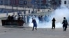 Supporters of Pakistan's former Prime Minister Imran Khan throw stones toward police during a protest against Khan's arrest, in Peshawar, Pakistan, on May 10.