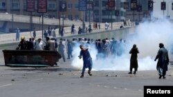 Supporters of Pakistan's former Prime Minister Imran Khan throw stones toward police during a protest against Khan's arrest, in Peshawar, Pakistan, on May 10.