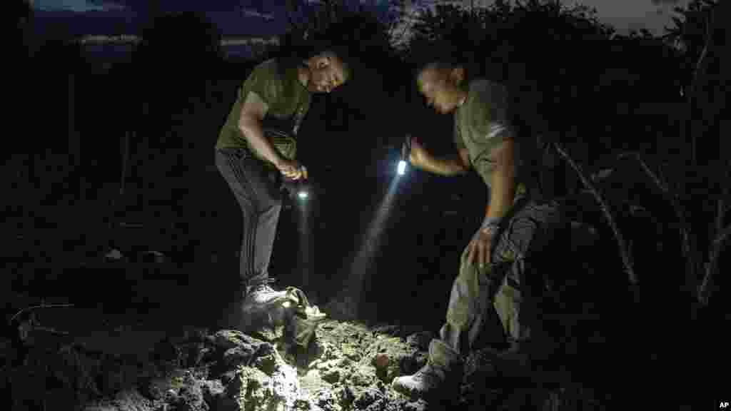 Ukrán rendőrök vizsgálják a krátert, amelyet egy lakónegyedet érő orosz rakéta vájt a földbe az ukrajnai Pokrovszkban 2023. június 21-én. A szerdai támadásban négy ember szenvedett könnyebb sérüléseket, köztük egy 2011-ben született gyermek