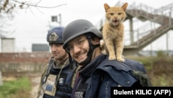 AFP journalist Arman Soldin smiles to a photographer as a cat stands on his shoulder during an assignment for AFP in Ukraine on November 11, 2022.
