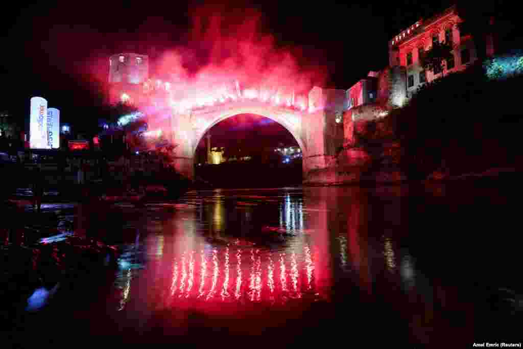 Mostar&#39;s Old Bridge is illuminated with flares during the night jump of the 458th edition of the traditional diving competition in Mostar, Bosnia-Herzegovina.