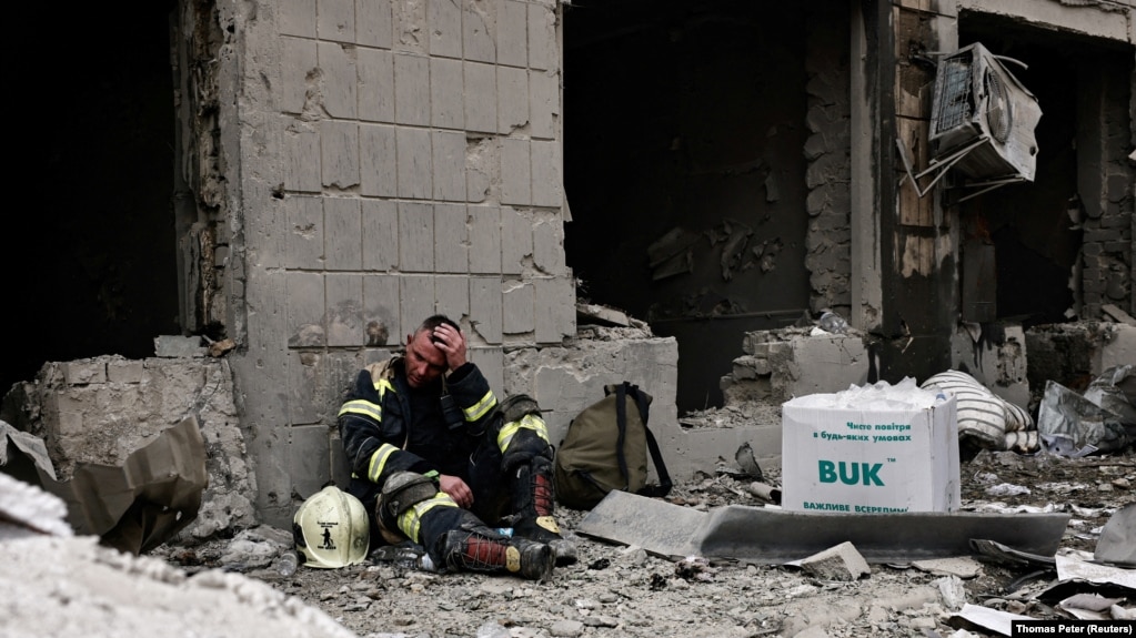 Рятувальник під стіною зруйнованої російським обстрілом будівлі дитячої лікарні «Охматдит»