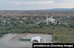 An aerial view of Aghdam in December 2023 showing the reconstructed mosque of the ruined city and a temporary shelter (in foreground) where Azerbaijani President Aliyev was shown plans for the city’s makeover.