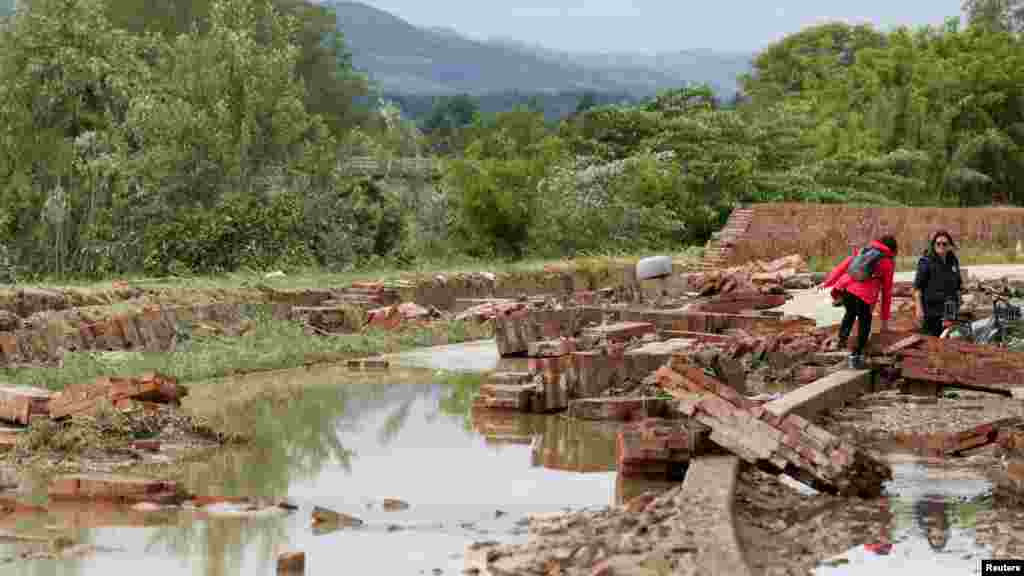 Oamenii trec prin apă în localiatea Faenza, după ce ploi abundente au lovit regiunea Emilia Romagna. REUTERS/Claudia Greco