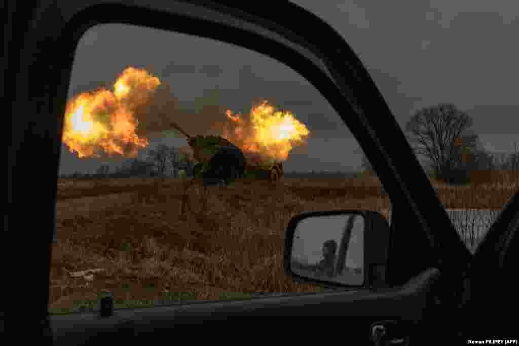 A Ukrainian soldier reflected in a car mirror looks at a Swedish-made Archer howitzer operated by members of the 45th Artillery Brigade.