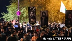 Mbështetësit e klerikut shiit irakian, Moqtada Sadr, duke protestuar në sheshin Tahrir, afër Zonës së Gjelbër të Bagdadit, në Irak, më 22 korrik 2023, një ditë pas djegies së dyshuar të një Kurani në Kopenhagë, Danimarkë.