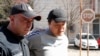 Do Kwon (right) is escorted to court in Podgorica on March 24. 