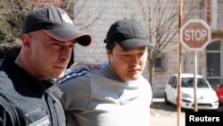 Do Kwon (right) is escorted to court in Podgorica on March 24. 