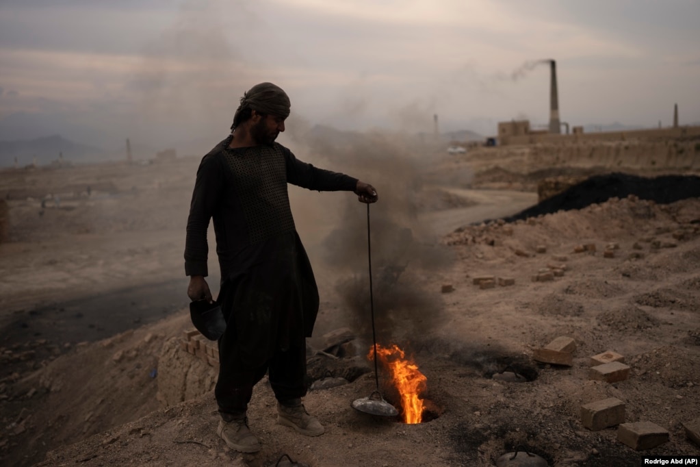 Një burrë duke punuar në një fabrikë tullash në periferi të Kabulit, Afganistan.