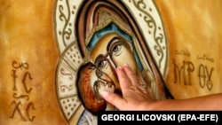 A Macedonian Orthodox believer touches an icon of the Virgin Mary. (file photo)