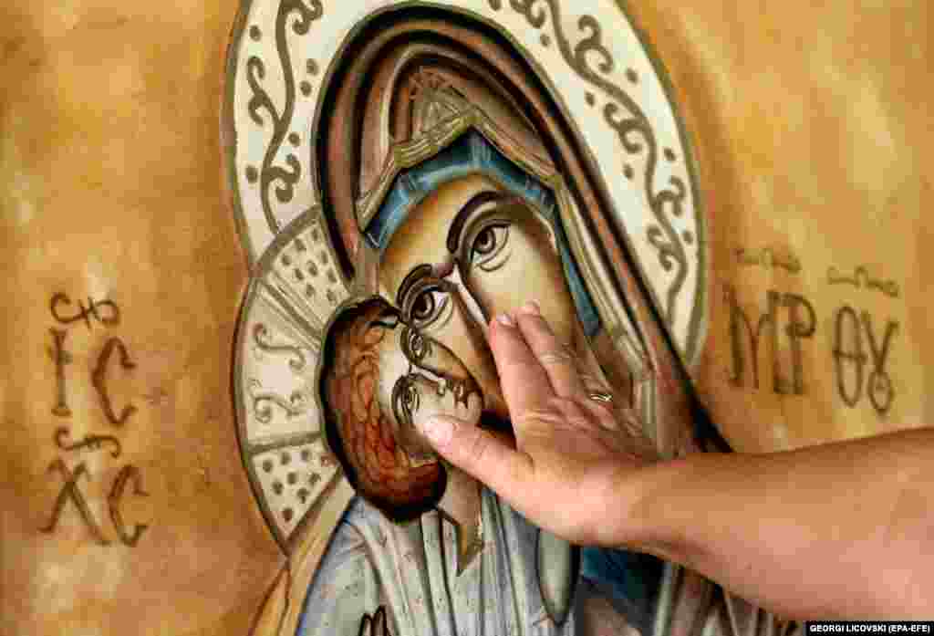 A Macedonian Orthodox believer touches an icon of the Virgin Mary during the Orthodox celebrations of the Assumption of Mary in the St. Mother of God church in Skopje, North Macedonia.