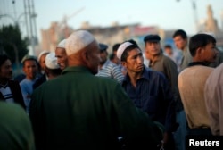 Мужчины-уйгуры собираются на рынке в Кашгаре, провинция Синьцзян, 3 августа 2011 года.