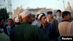 Мужчины-уйгуры собираются на рынке в Кашгаре, провинция Синьцзян, 3 августа 2011 года