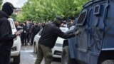 An masked man spray-paints the letter "Z" on to a security forces' vehicle during protests in Zvecan, northern Kosovo, on May 29. 