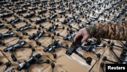 Украинский военнослужащий показывает FPV-дроны, предоставленные фондом Come Back Alive одной из украинских воздушно-десантных бригад, на фоне нападения России на Украину, в Киеве, Украина, 14 февраля 2024 года