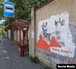 O pictură murală de protest cu cuvintele „Politica mașinii de tocat carne” în regiunea Kaluga din Rusia