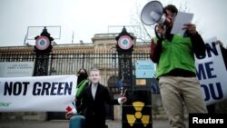 Ekološki aktivisti, s maskom francuskog predsednika Emmanuela Macrona, protestuju zbog nastojanja Francuske da uključi nuklearnu energiju i fosilni plin u EU Zelenu taksonomiju, Pariz, 14. decembar 2021. 