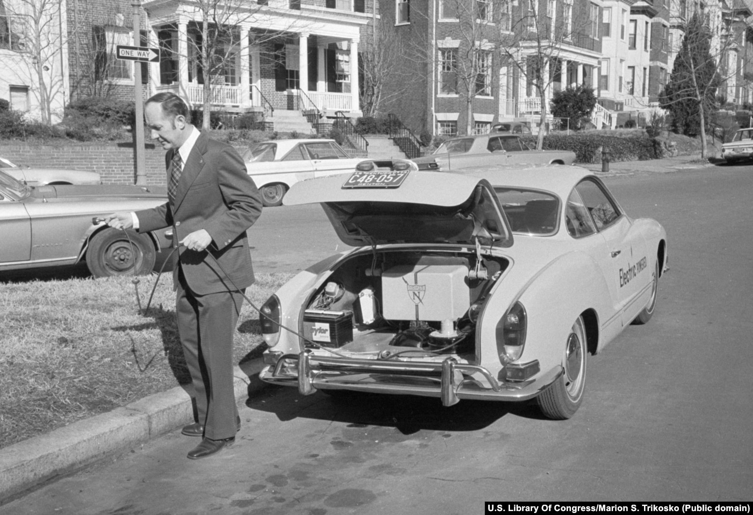 Një burrë duke u përgatitur të furnizojë automjetin e tij elektrik në një vend të paidentifikuar në Shtetet e Bashkuara, në shkurt të vitit 1974.