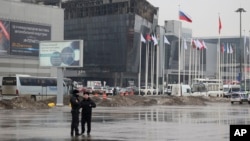 Російські силовики стоять біля концертної зали «Крокус Сіті Хол» у місті Красногорську під Москвою, де внаслідок теракту загинули понад 130 людей 