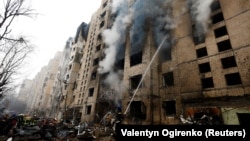 Пожарникарите во Киев го гасат пожарот во станбена зграда која била оштетена за време на руски ракетен напад на 2 јануари 2024 година