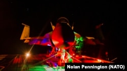  Моряци правят рутинна поддръжка на военен аероплан F/A-18F Super Hornet на палубата на най-големия самолетоносач в света 