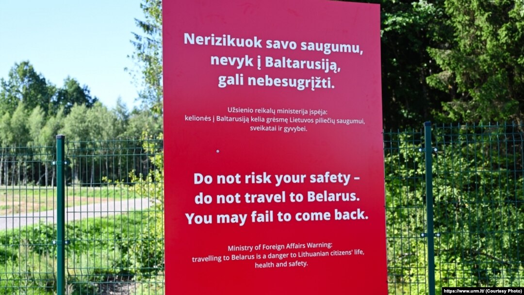 A sign on the border of Lithuania warns against traveling to Belarus.