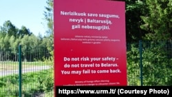 A sign on the border of Lithuania warns against traveling to Belarus.