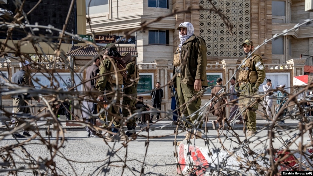 Taliban fighters stand guard at the site of the explosion near the Foreign Ministry in Kabul on March 27.