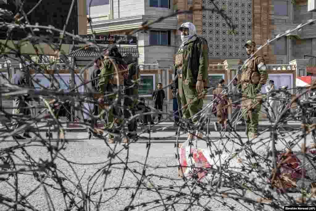 Taliban fighters stand guard at an explosion site near the Foreign Ministry in Kabul on March 27.