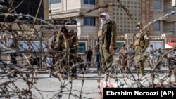 Taliban fighters stand guard at the site of the explosion near the Foreign Ministry in Kabul on March 27.