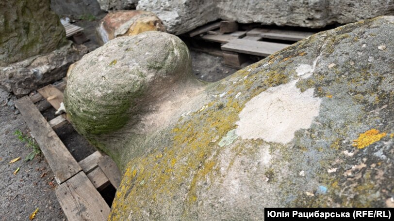 A stone sculpture bears apparent shrapnel damage.