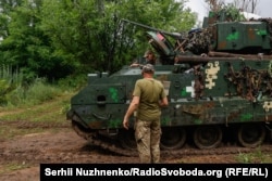 Український військовий біля американської бойової машини піхоти (БМП) M2. Україна, червень 2023 року