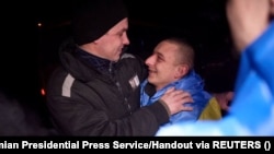 Ukrainian prisoners of war react after a swap at an undisclosed location in Ukraine on February 8.