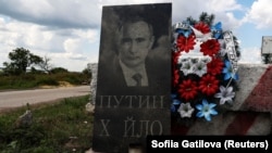 Імітація надгробної плити із зображенням президента Росії Володимира Путіна на блокпості в Донецькій області, 10 липня 2023 року