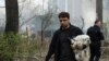 Місцевий житель зі своєю собакою на місці прильоту. Харків, 7 квітня 2024 року